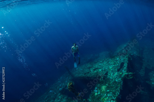 Free diver man dive underwater at shipwreck in Bali