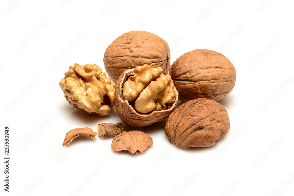 Walnuts and kernels, two whole walnuts, kernels and shell pieces, close-up macro, isolated on a white background. Walnuts and kernels, two whole walnuts, kernels and shell pieces, close-up macro, isolated on a white background.