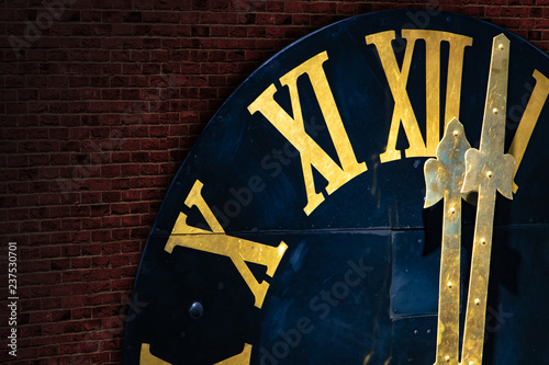 The clock with gilded Roman numerals shows twelve hours. The midnight on tower clock from bricks. photo