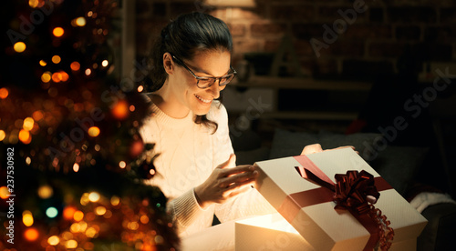 Woman opening a magical Christmas gift