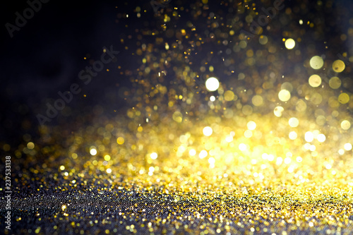 Abstract Sprinkle glitter gold dust on black background textured ,elegant and luxury concept