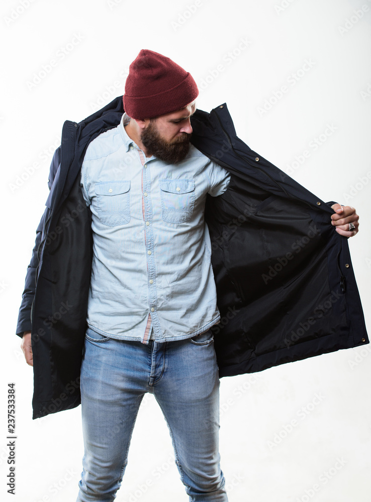 Guy wear hat and black winter jacket. Stylish and comfortable. Hipster  style menswear. Hipster outfit. Man bearded hipster stand in warm black  jacket parka isolated on white. Hipster modern fashion Stock Photo