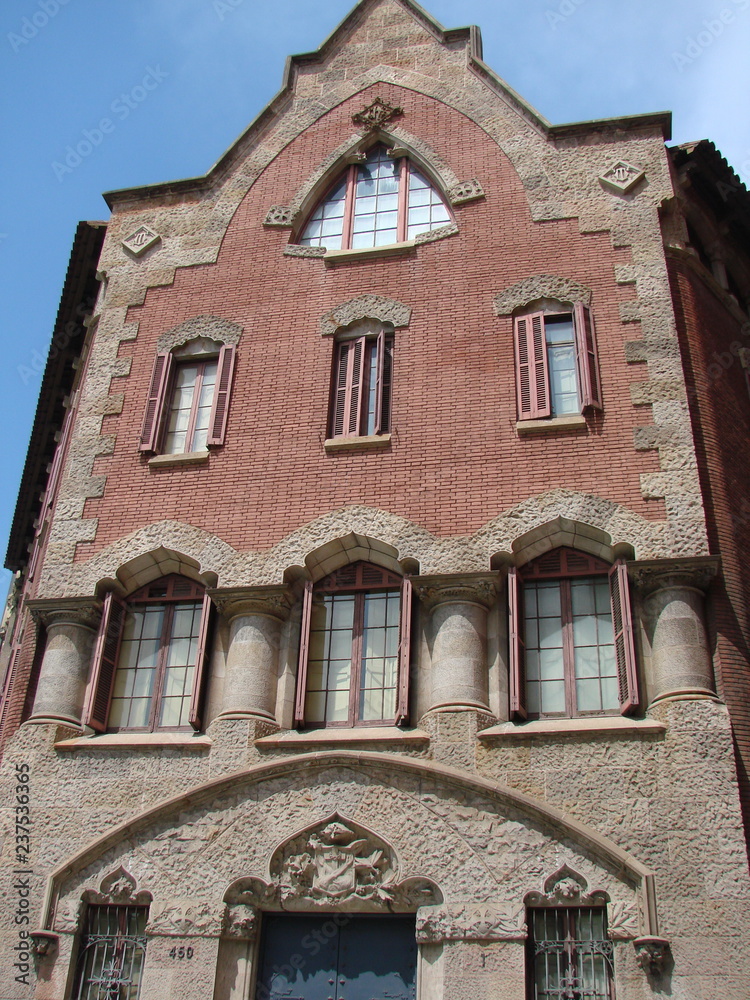 Masterpieces of ancient medieval Catholic architecture on the streets of the historic city of Barcelona on the background of a cloudy blue sky.