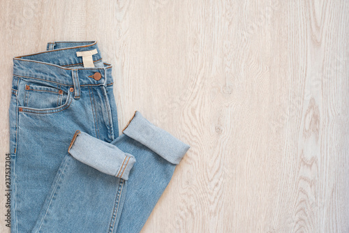 Blue jeans on a wooden background. Flat lay of female styled look. Top view. Shopping Concept. Fashion Outfits