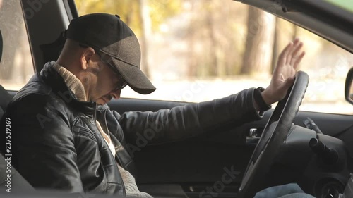 A private detective or a spy conducts surveillance of the object of surveillance. A man secretly taking pictures from the car window