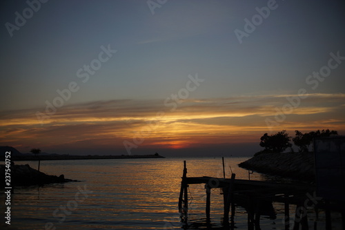 Fototapeta Naklejka Na Ścianę i Meble -  silhouette of harbor ,Orange and red sky sunset on the beach.