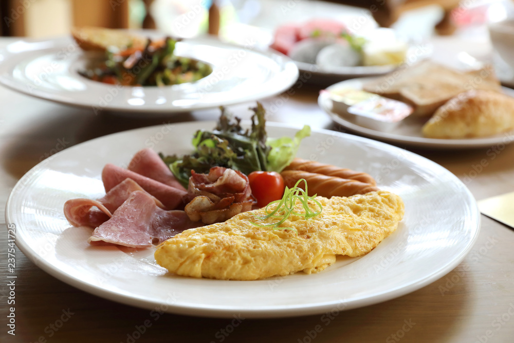 Breakfast set Omelette with sausage bacon and salad on wood background Breakfast set Omelette with sausage bacon and salad on wood background