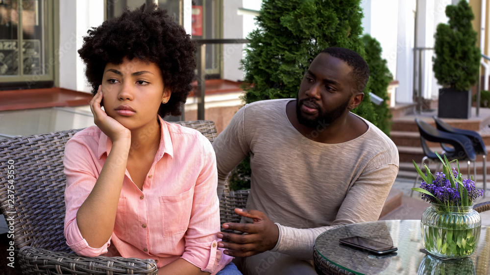 Upset offended girl ignoring boyfriend, turned away, misunderstanding, conflict Upset offended girl ignoring boyfriend, turned away, misunderstanding, conflict