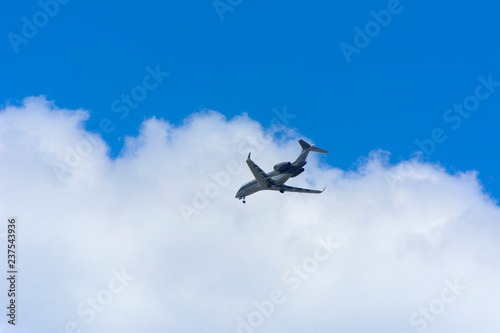 A large passenger airliner is a plane with a big wingspan high in the sky. Transport tourists for exotic holidays against the blue sky and white clouds