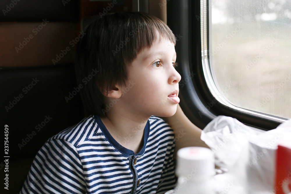 Lovely little boy looks out of window in the train Lovely little boy looks out of window in the train