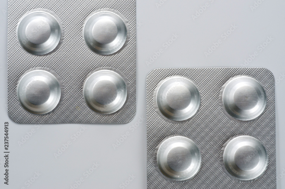 Plate with round medical pills silver color close-up shot Plate with round medical pills silver color close-up shot