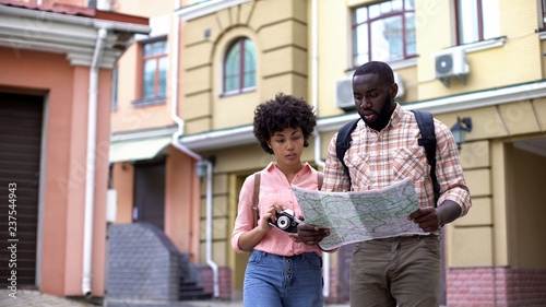 Tourists with map and photo camera  choosing direction  travelling vacation