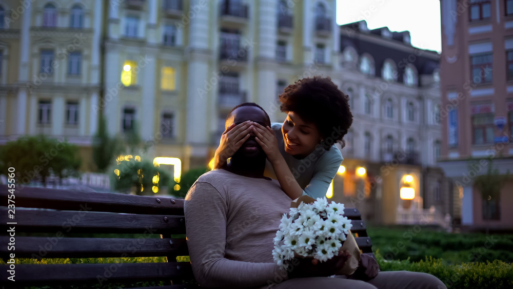 Beautiful girl covering boyfriend eyes behind, happy couple meeting on date Beautiful girl covering boyfriend eyes behind, happy couple meeting on date