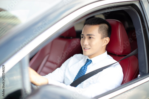 smiling  young business man  driving a car © Tom Wang