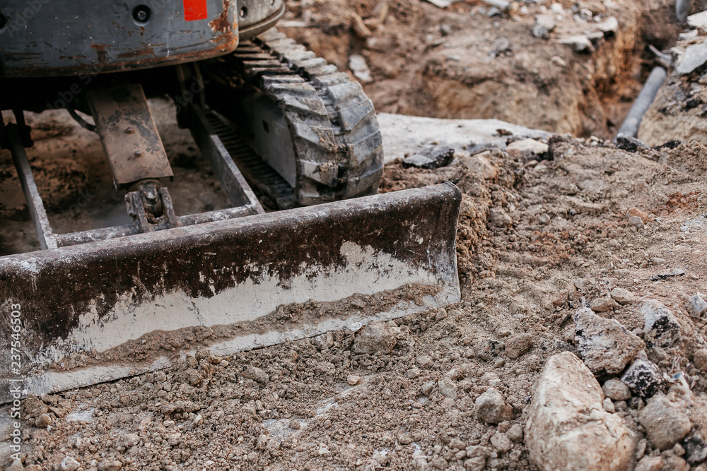 Close up of bulldozer working with soil on construction site Close up of bulldozer working with soil on construction site