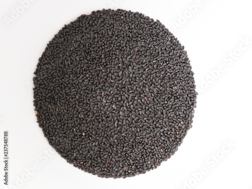 Chia seeds lie on a round white surface.