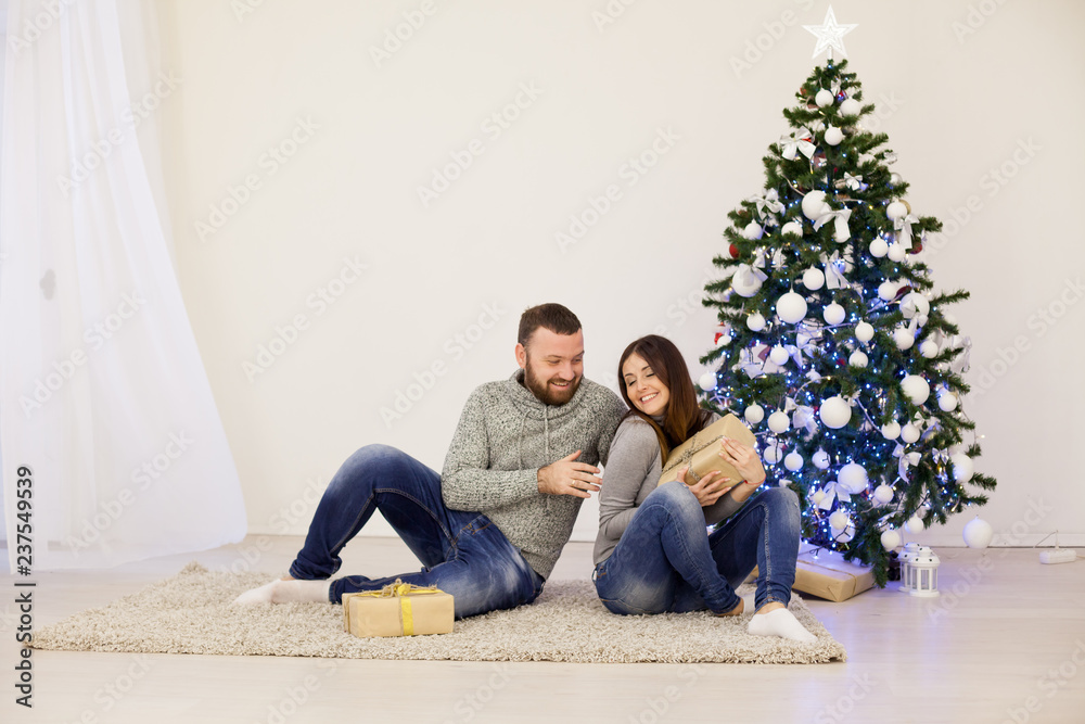 man and woman open Christmas presents Christmas tree with Garland new year man and woman open Christmas presents Christmas tree with Garland new year