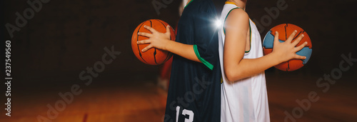 Two Boys Basketball Team Players Holding Basketballs on the Wooden Court. Basketball Training For Kids. Horizontal Background of Youth Basketball Players, Copy Space © matimix