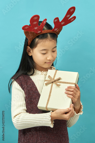 Asian girl with a Christmas concept headdress Child, Close up of cute little asian girl on blue background isolated.
