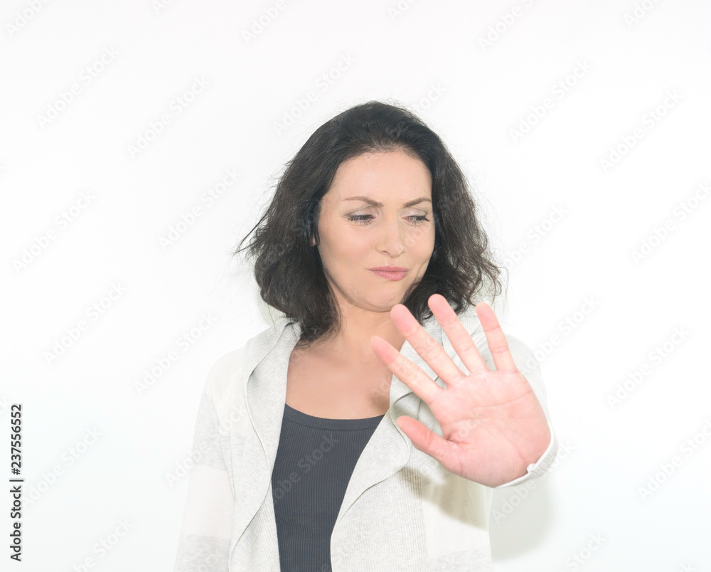 Young woman is showing stop gesture with her hand. Isolated on a white background. Young woman is showing stop gesture with her hand. Isolated on a white background.