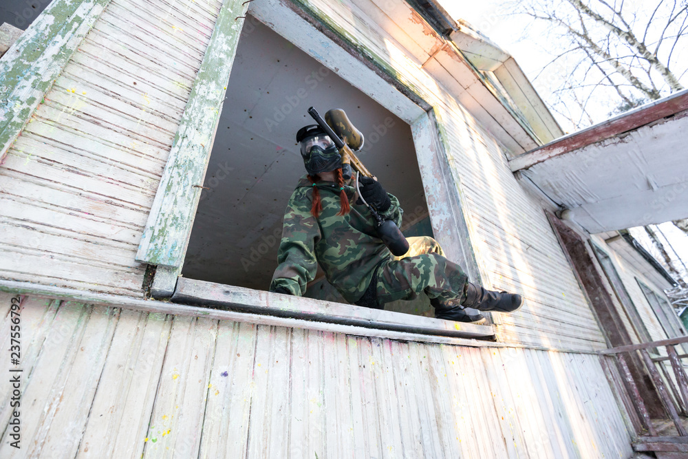 Paintball sportsman extreme jumping from the window of abandoned house