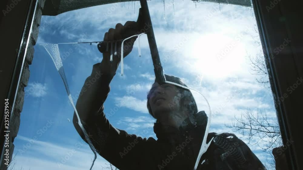 Caucasian man washes the wiper with a dirty window outside