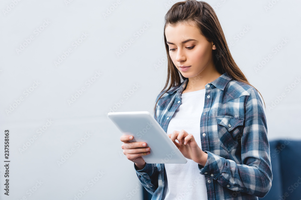 beautiful girl in checkered shirt using digital tablet at home beautiful girl in checkered shirt using digital tablet at home