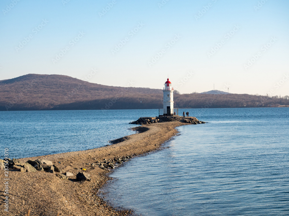 Tokarevsky lighthouse and people in the background of the Russian island of the Far Eastern city of Vladivostok. December, 2018