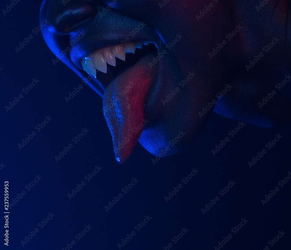 Female mouth with sharp fangs and bloody tongue. Halloween Horror night.  Stock Photo | Adobe Stock