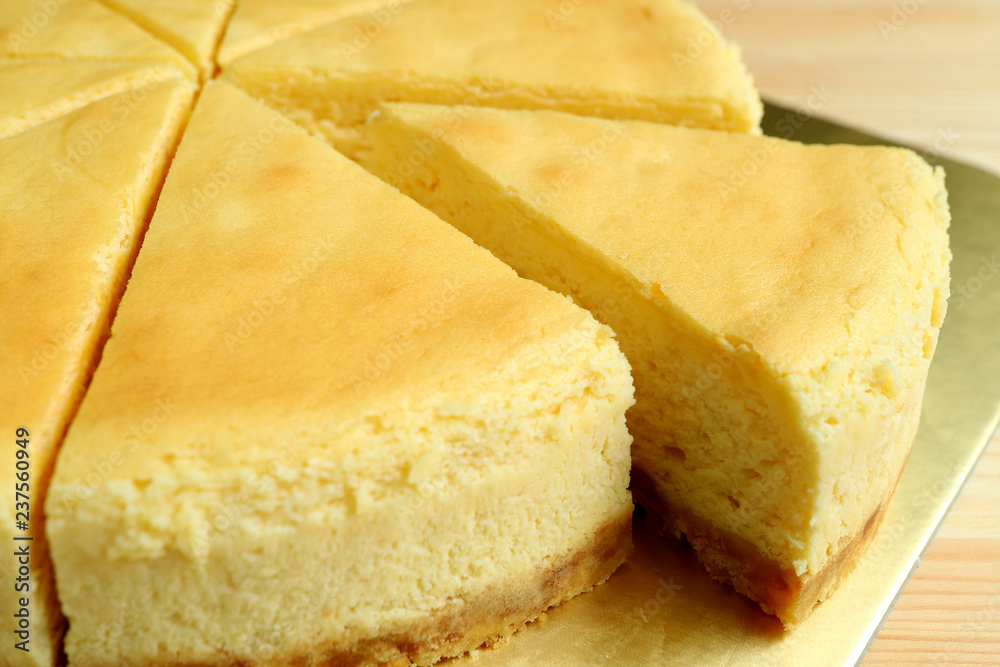 Closed up a piece of creamy yellow plain baked cheesecake cut from the whole cake Closed up a piece of creamy yellow plain baked cheesecake cut from the whole cake