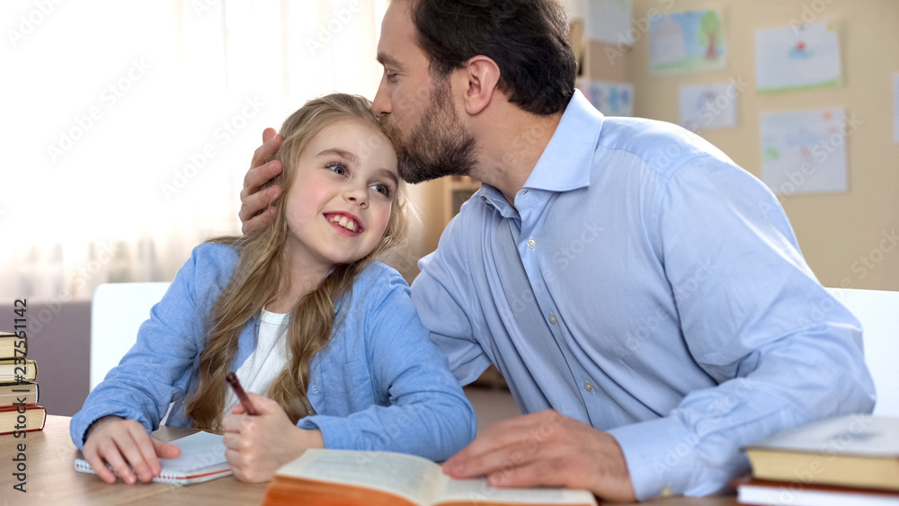 Proud father doing homework together with his daughter, education, family care Proud father doing homework together with his daughter, education, family care