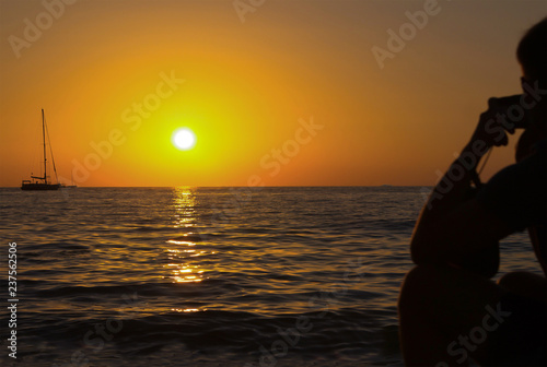 yacht sailing bright sunset golden sun silhouette of a man on the shore looking into the distance on a ship in the sea