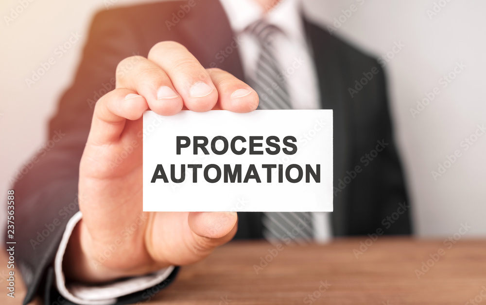 Businessman holding a card with text Process Automation Businessman holding a card with text Process Automation