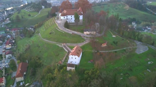 Aerial: Flying beside city Sevnica beside river Sava in Slovenia. Beautiful small city with castle is the birth place of first lady Melania Trump. photo