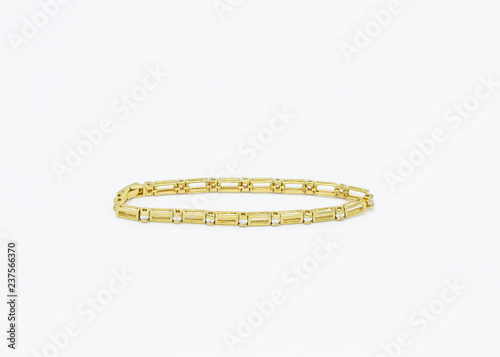 narrow gold metal bracelet made with rectangular links separated by clear beads