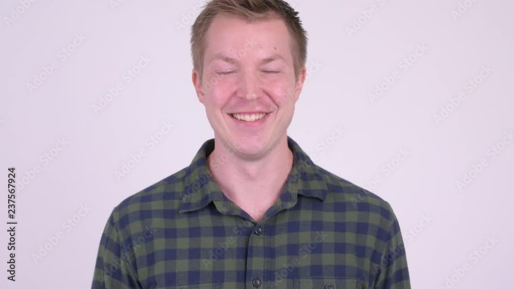 Face of young man smiling, thinking, and laughing against white background Face of young man smiling, thinking, and laughing against white background