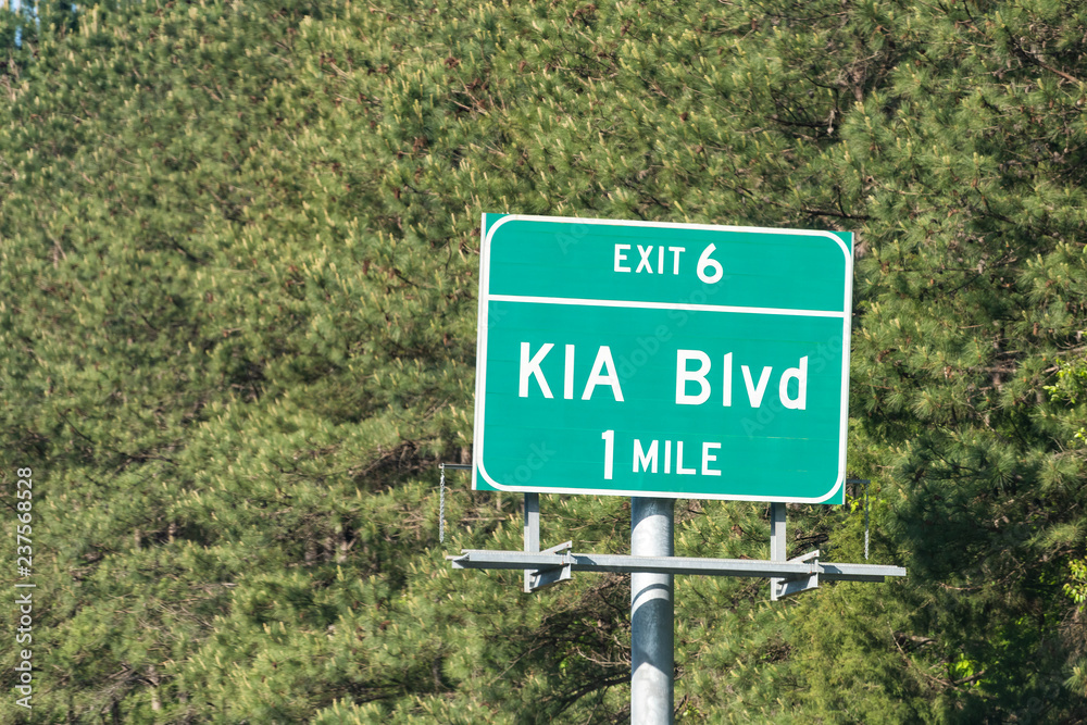 West Point, USA - April 21, 2018: Highway, road sign for Kia Boulevard, Blvd in one, 1 mile, exit 6 to motors manufacturing assembly facility, plant factory