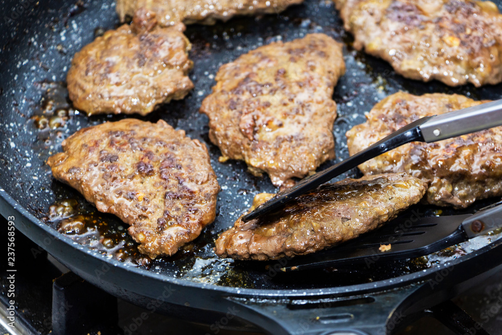 big and juicy cutlet on a metal stand. Home kitchen