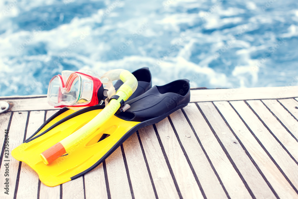 Obraz premium Summertime and holiday concept. Sea view. Diving mask and flippers lelft on boat.