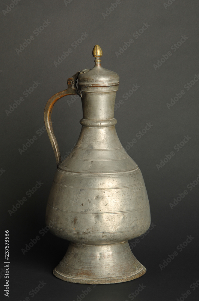 ancient oriental metal jug on dark background. antique bronze tableware ancient oriental metal jug on dark background. antique bronze tableware