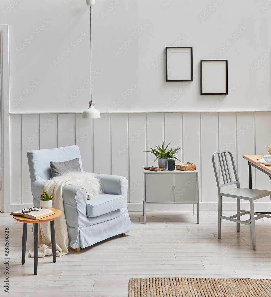 Fototapeta premium Decorative home design interior with blue armchair lamp and coffee table. Grey cabinet and frame decor.