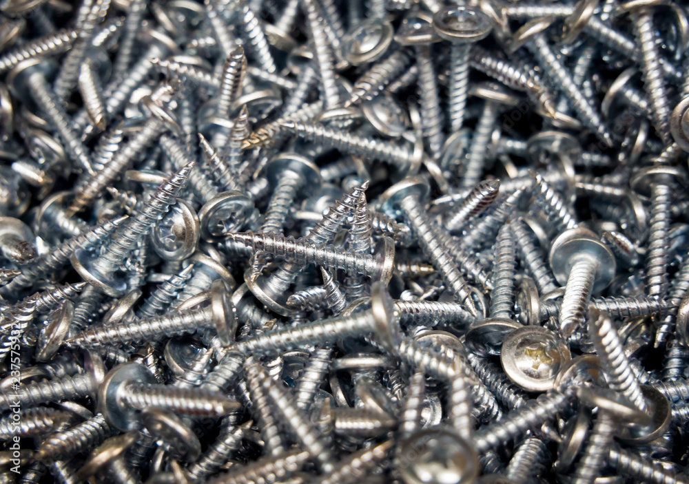 Background image of small screws in bulk Background image of small screws in bulk