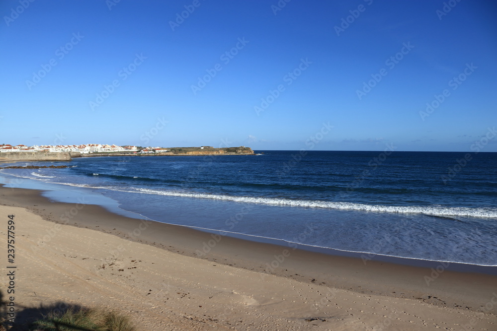 beach of gâmboa in Peniche with  the city in the background