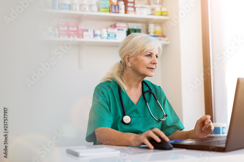 Φωτογραφία Senior female doctor using laptop in her office