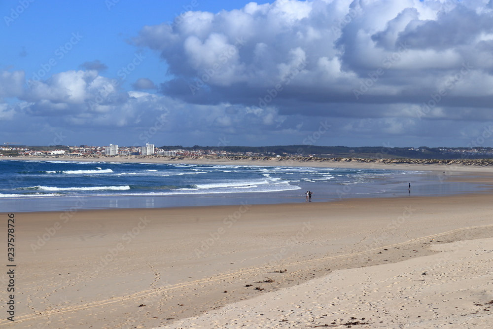 people on the beach with gray sky and full of clouds