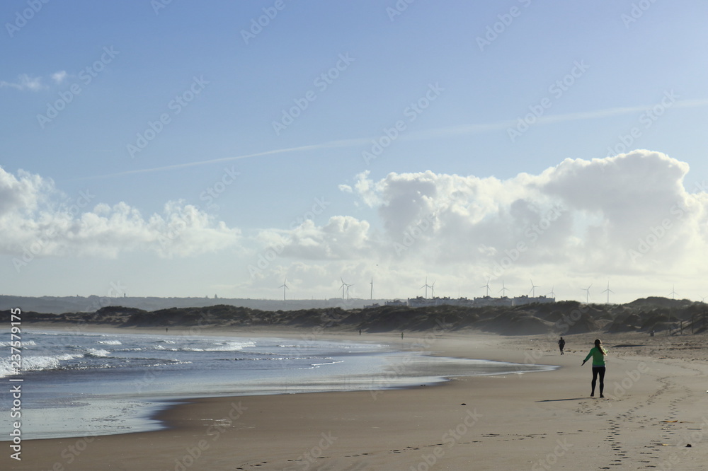 woman doing exercise on the beach with cloudy sky in the background