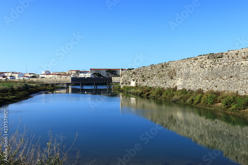 old fort in the water with bridge in the background