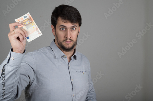 young man with a beard, with euros in his hand