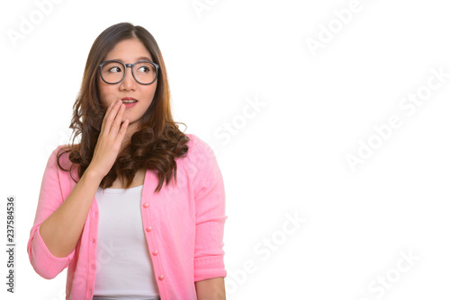 Portrait of young beautiful Asian woman looking shocked
