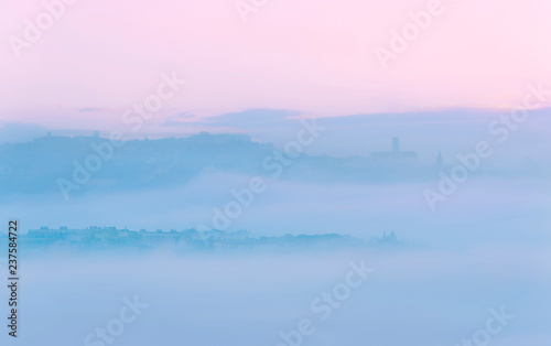 Paesaggio avvolto dalla nebbia all'alba